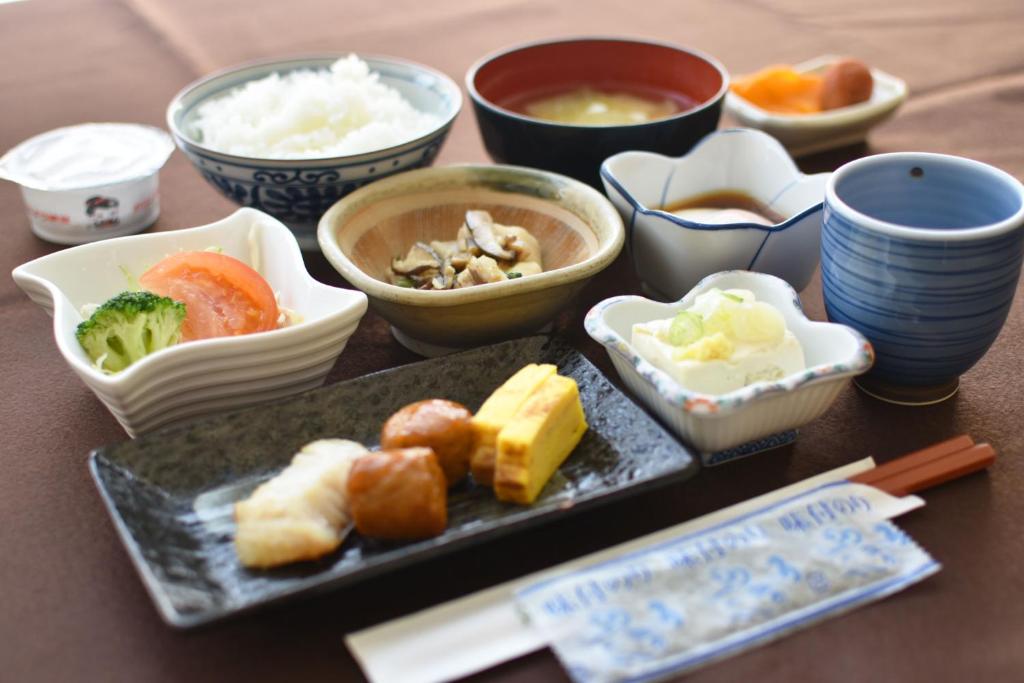 une table recouverte de assiettes et de bols de nourriture dans l'établissement Nayoro Onsen Sunpillar, à Nayoro
