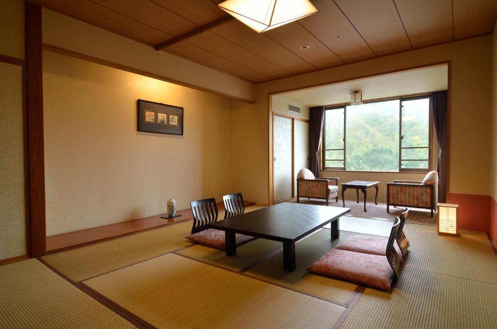 un salon avec une table et des chaises et une fenêtre dans l'établissement Jozankei Manseikaku Hotel Milione, à Jozankei