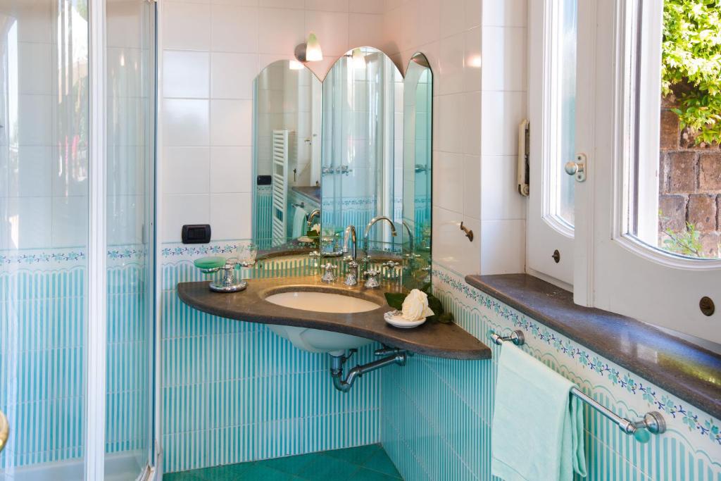 une salle de bain avec un lavabo et un miroir dans l'établissement Villa Eugenia, à Sant'Agnello