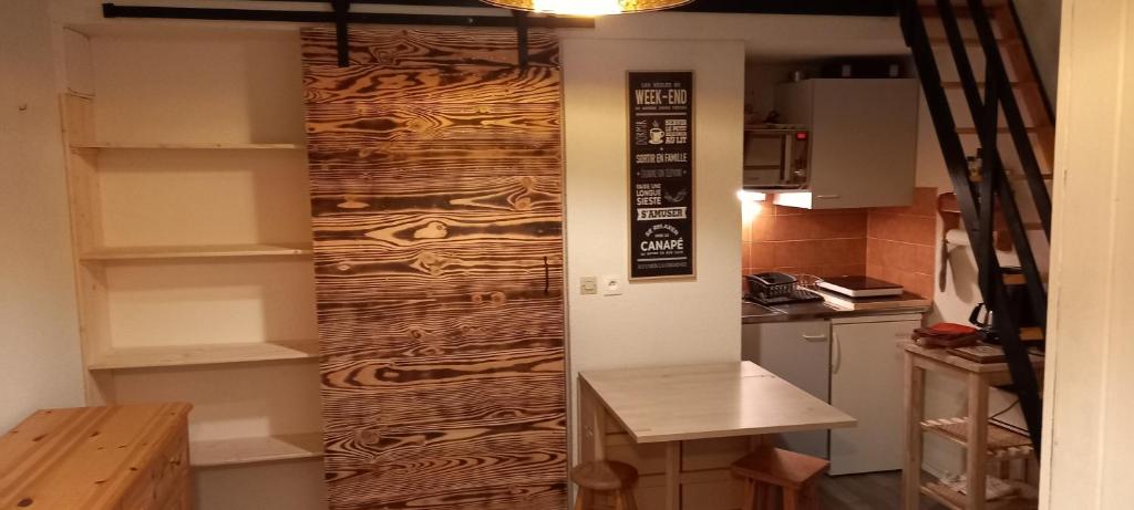 Cette chambre dispose d'une cuisine avec un mur en bois. dans l'établissement Duplex Arc en Ciel - Les Deux Alpes, à Mont-de-Lans