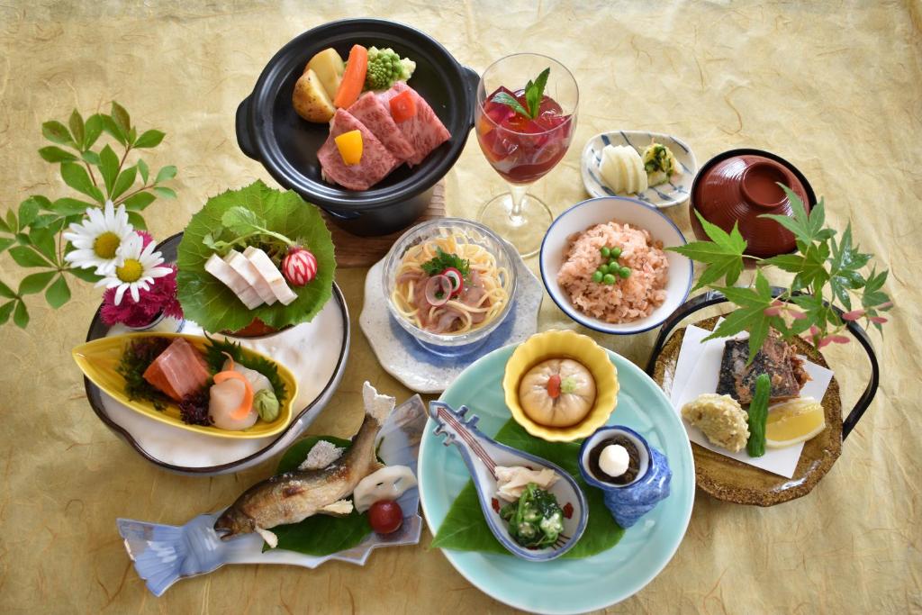 une table avec de nombreuses assiettes de nourriture dessus dans l'établissement Shiobara Onsen Tokiwa Hotel, à Nasushiobara