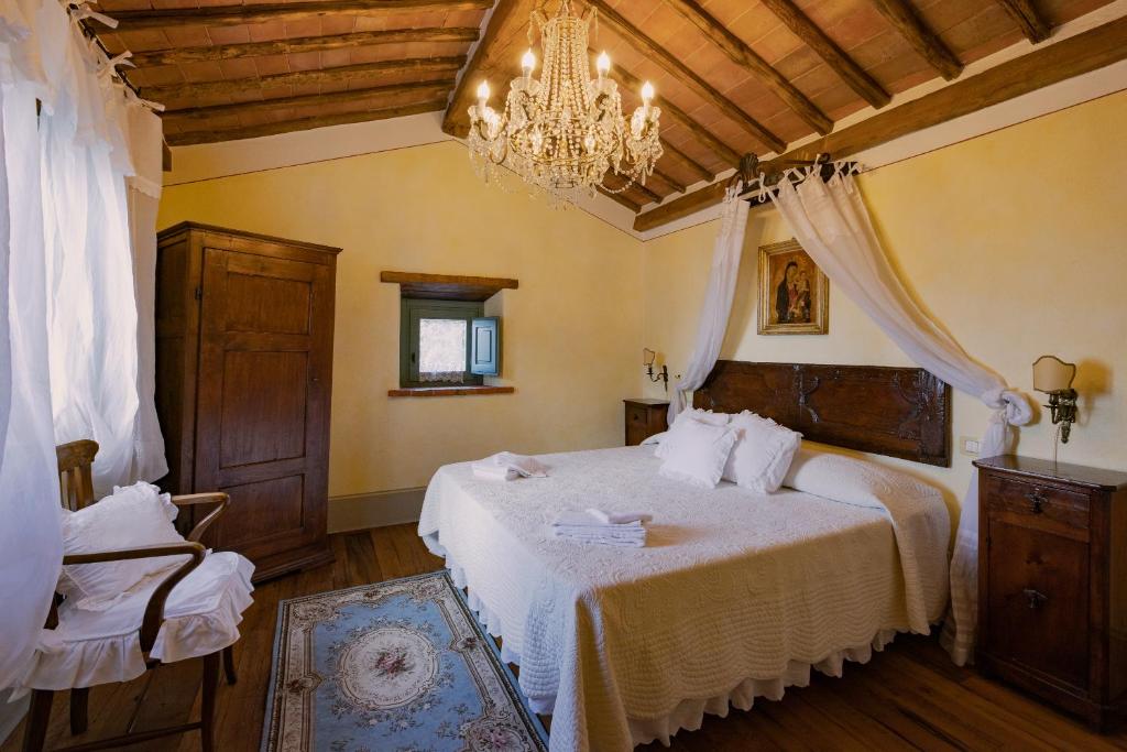 une chambre avec un lit et un lustre dans l'établissement Casa Lamate, à Cortone 42 autres photos
