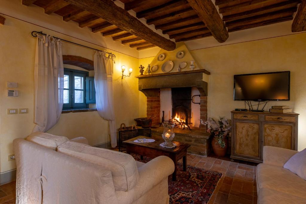 un salon avec un canapé et une cheminée dans l'établissement Casa Lamate, à Cortone