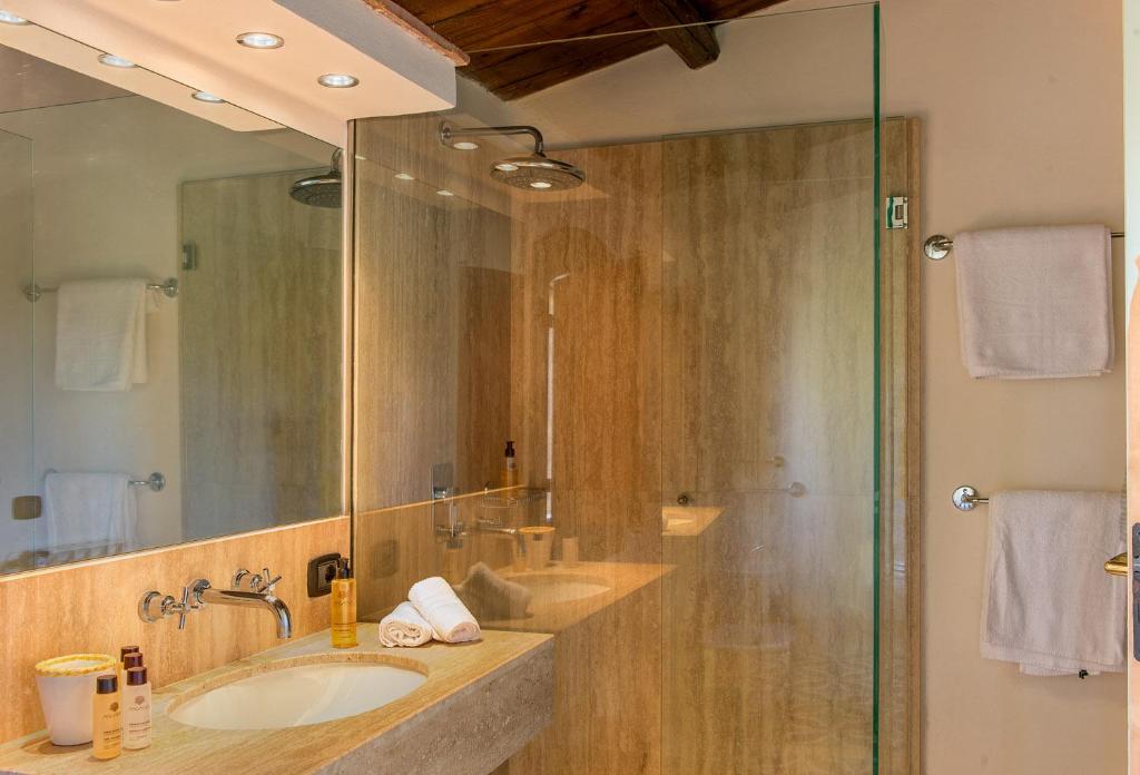 une salle de bain avec un lavabo et une douche avec un miroir dans l'établissement Luxury Sicily Villas by Geocharme, à Castelvetrano