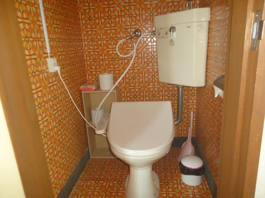 une petite salle de bain avec toilettes dans une chambre dans l'établissement Cafe Cerisier栖里時絵, à Myōkō
