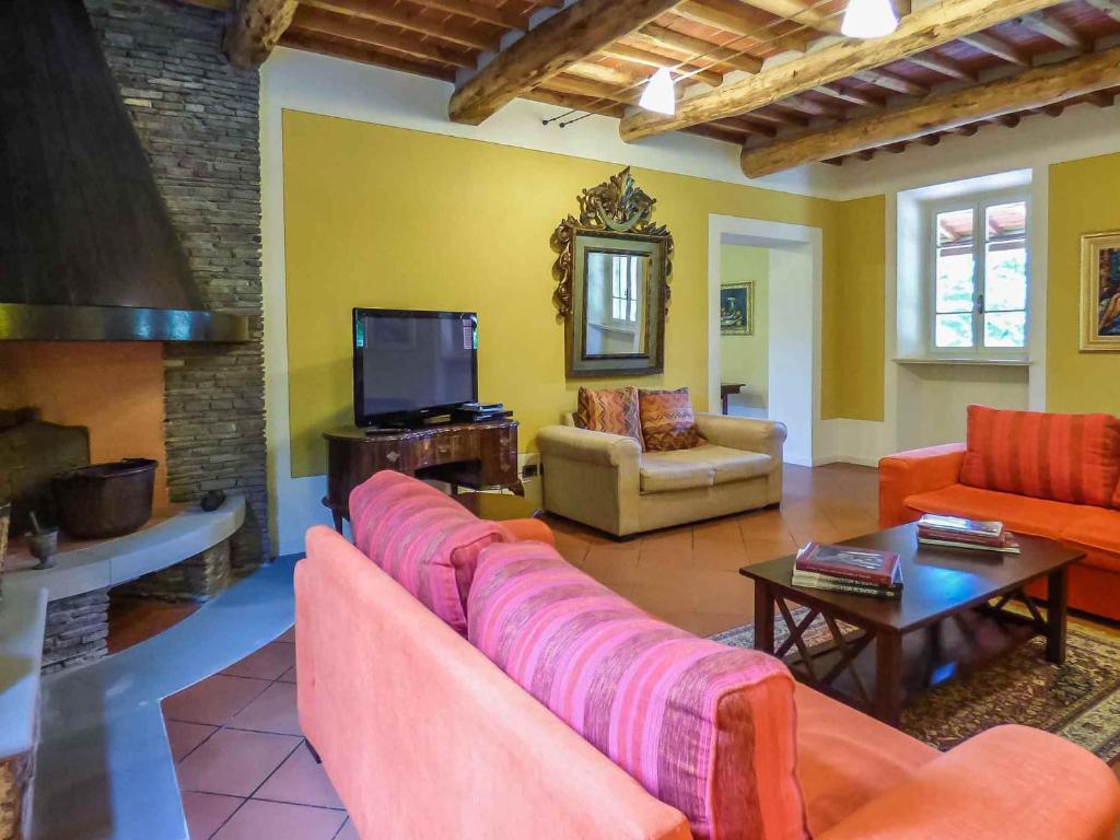 un salon avec un canapé et une télévision dans l'établissement Lucca Cycling Holidays Il Tiglio, à Lucques