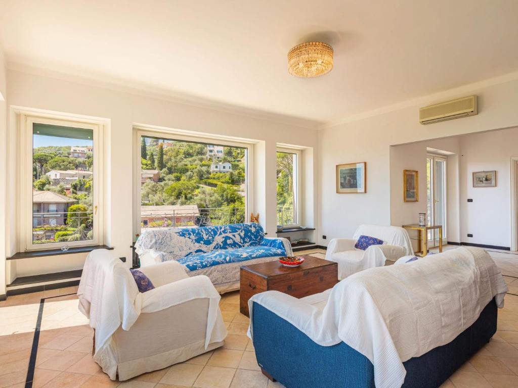 un salon avec un canapé, des chaises et des fenêtres dans l'établissement Villa Aldo by Interhome, à Rapallo