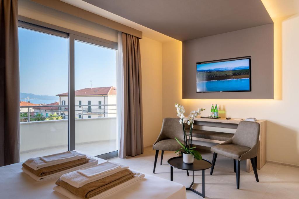 une pièce avec une table et des chaises et une grande fenêtre dans l'établissement Palace Lido Hotel & Suites, à Marina di Cecina 32 autres photos