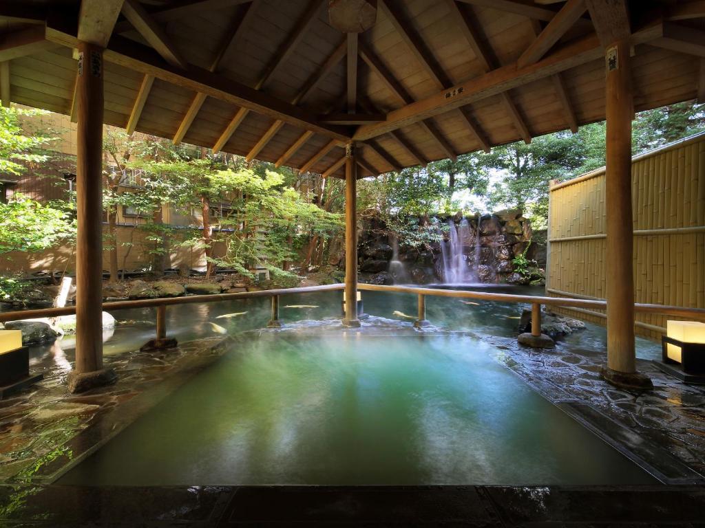 une piscine d'eau en face d'une cascade dans l'établissement Club Wyndham Chikumakan Nagano, à Chikuma
