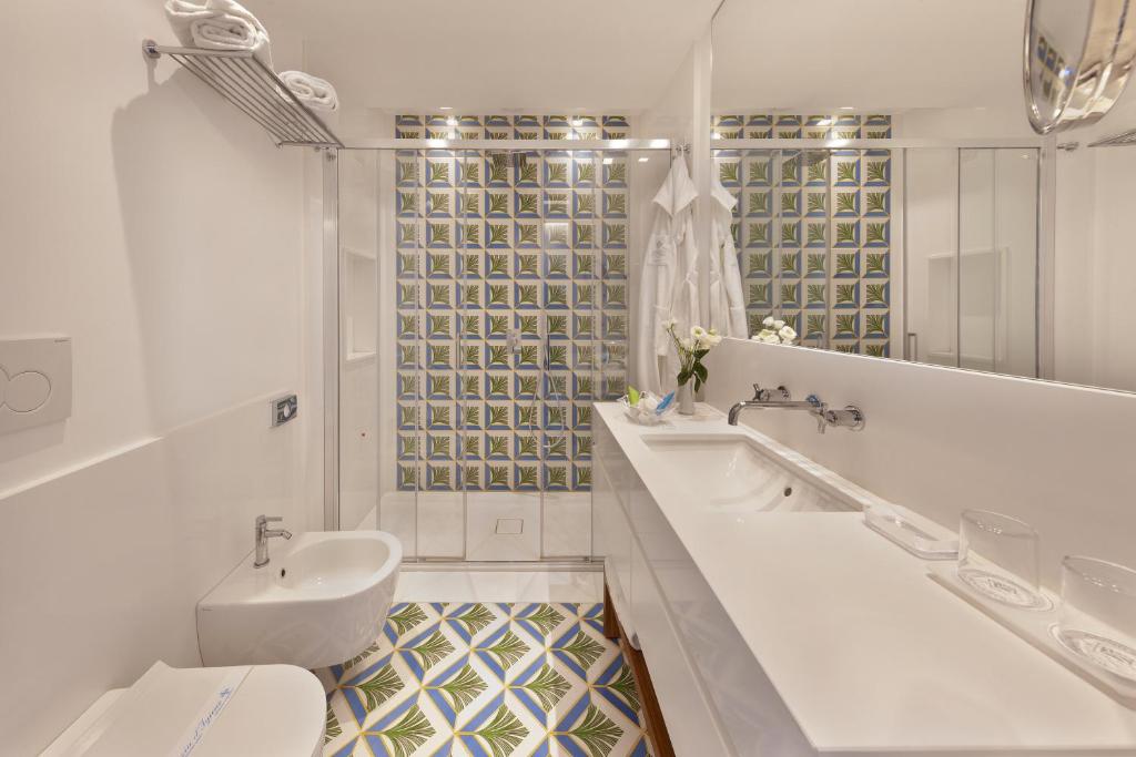 une salle de bain blanche avec un lavabo et des toilettes dans l'établissement Grand Hotel Riviera, à Sorrente
