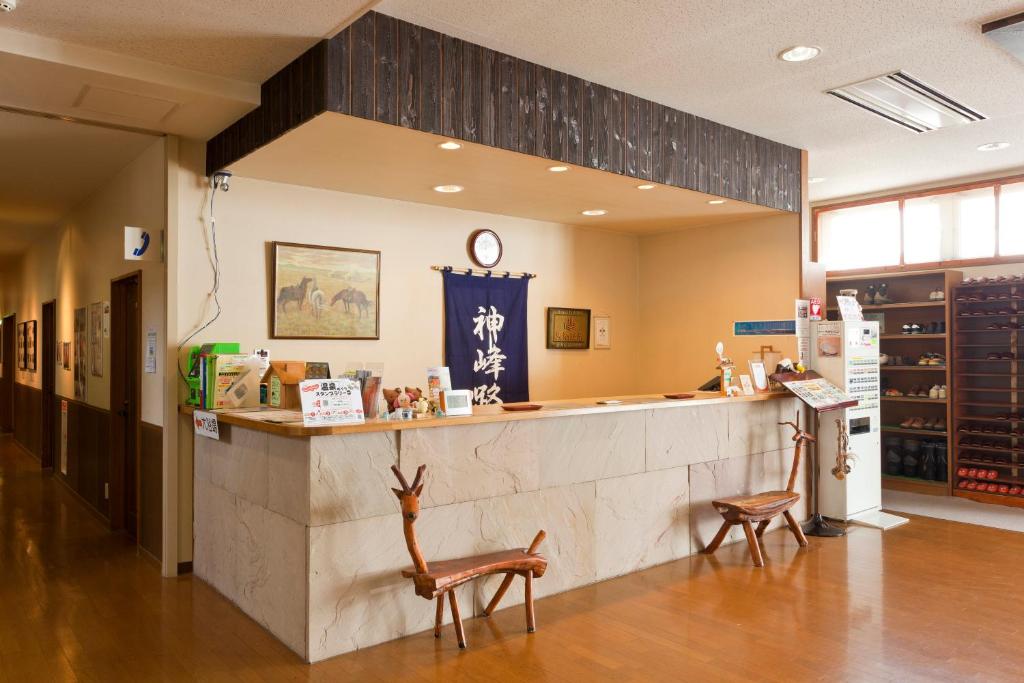 un restaurant avec un comptoir et deux chaises dans l'établissement Kamihoroso, à Kami-furano