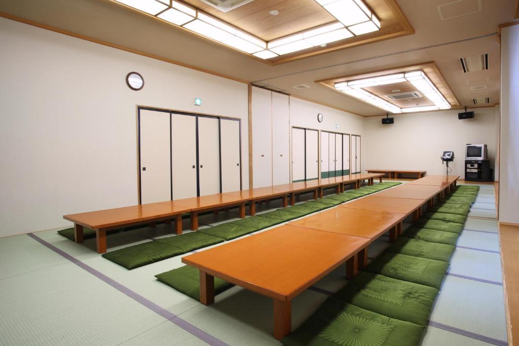 une rangée de tables dans une pièce avec des tapis verts dans l'établissement Kamihoroso, à Kami-furano 37 autres photos