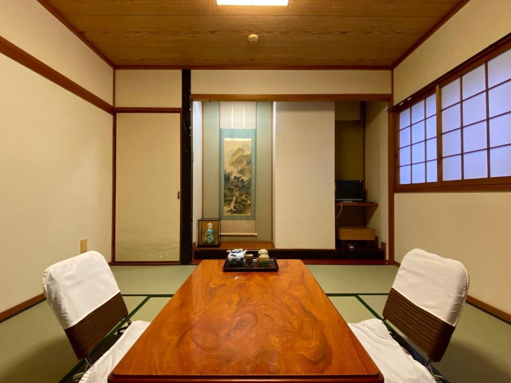 une salle de conférence avec une table en bois et deux chaises dans l'établissement Toyofuku, à Kobe 23 autres photos