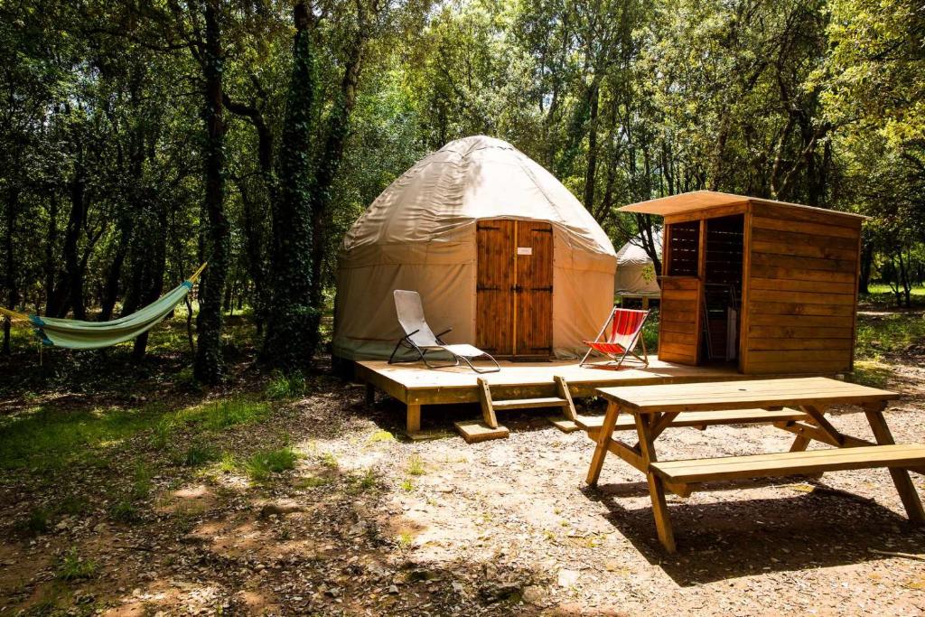 une yourte avec un banc, une table et une table de pique-nique dans l'établissement Camping Mille Étoiles, à Labastide-de-Virac