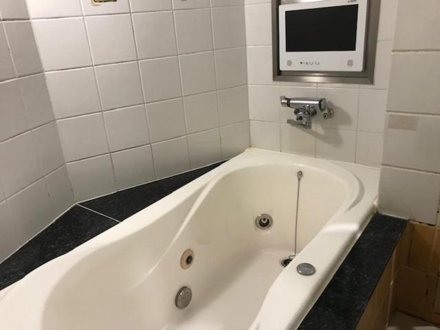 une baignoire blanche dans une salle de bain avec une télévision dans l'établissement Hotel Fairy Tale (Adult Only), à Toyonaka