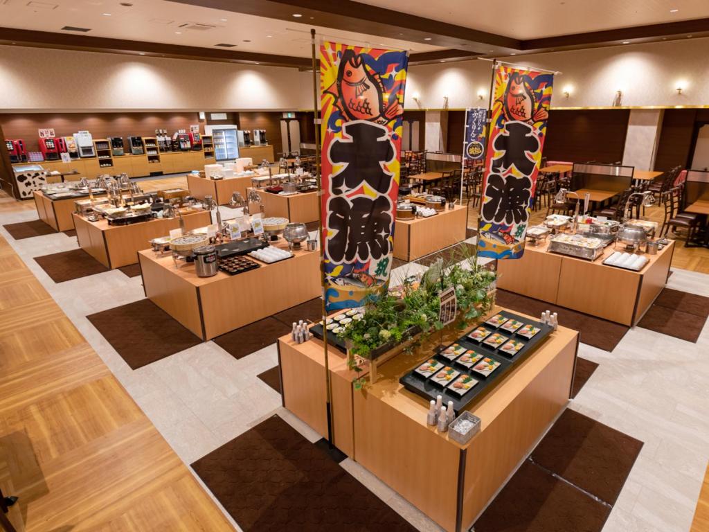 une salle à manger avec des tables et des chaises ainsi qu'un buffet dans l'établissement Yunokawa Kanko Hotel Shoen, à Hakodate