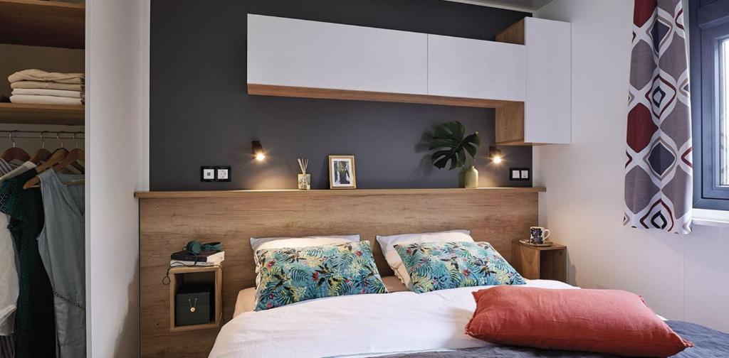 une chambre avec un lit avec deux oreillers dans l'établissement Camping la Haie Penée ****, à Saint-Quentin-en-Tourmont