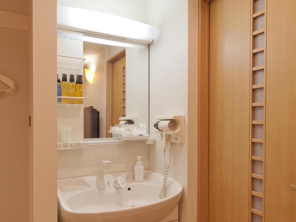 une salle de bain avec un lavabo et un miroir dans l'établissement Hotel Fine Aroma Dotonbori, à Osaka 16 autres photos