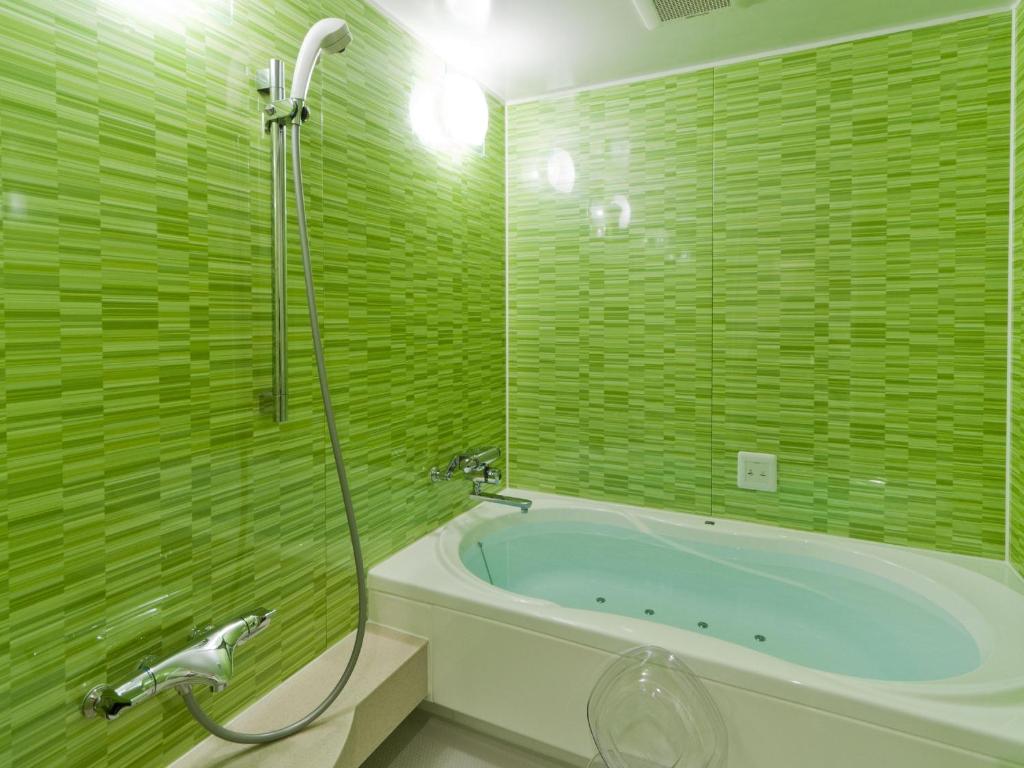 une salle de bain verte avec baignoire et douche dans l'établissement Hotel Fine Aroma Tennoji, à Osaka 21 autres photos
