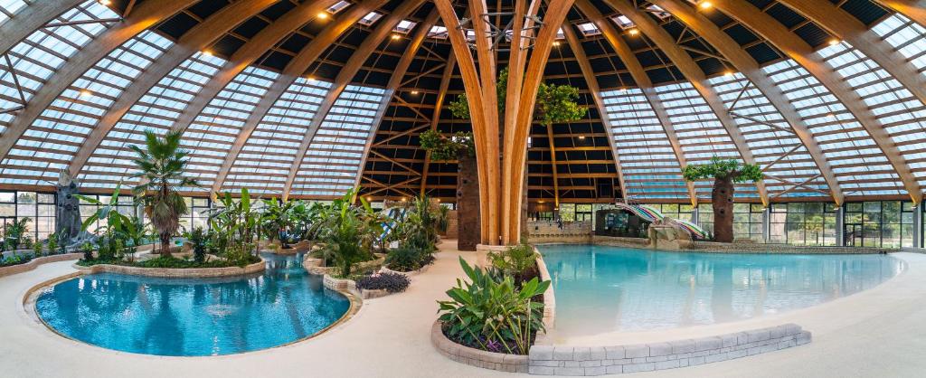 une grande piscine intérieure dans un immeuble dans l'établissement Domaine des Ormes by Home From Home, à Dol-de-Bretagne