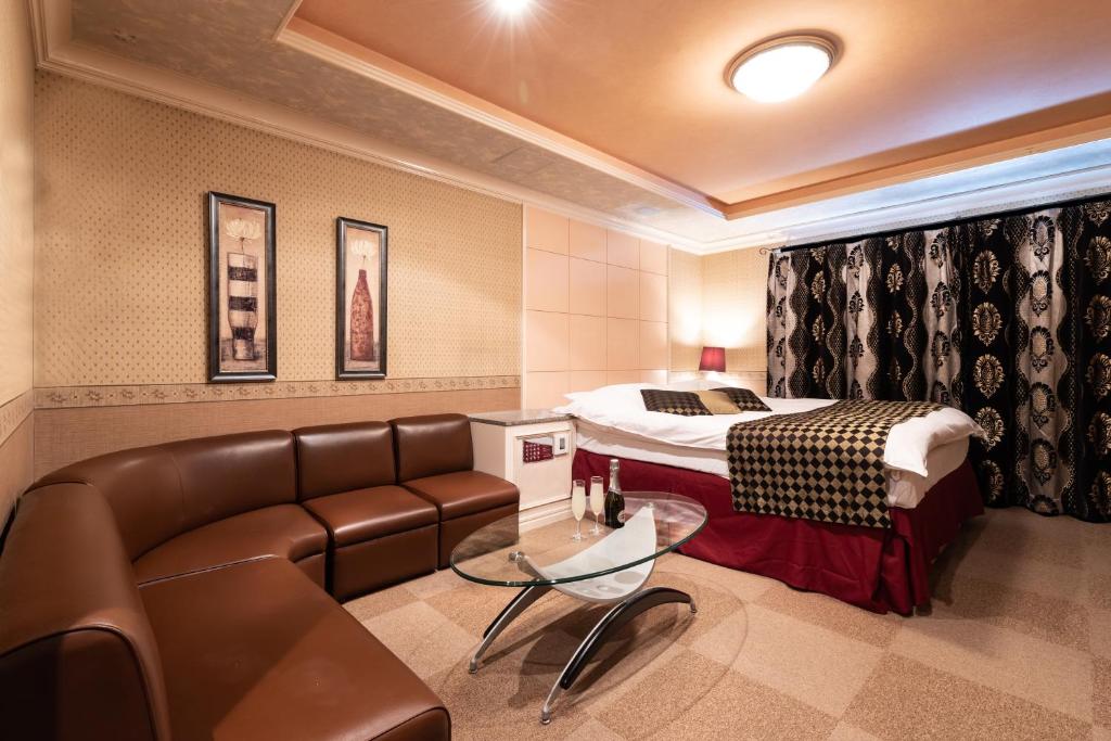 une chambre d'hôtel avec un canapé et un lit dans l'établissement ホテル ムービームービー 岐阜, à Gifu