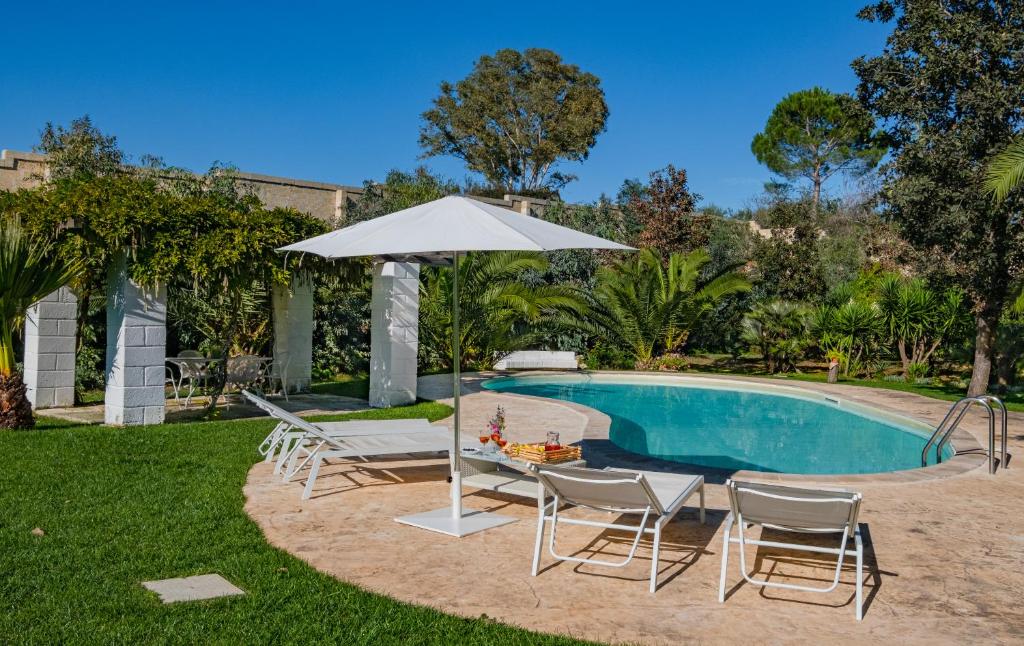 - une piscine avec des chaises, une table et un parasol dans l'établissement Villa Flem Luxury by HDSalento, à Montesano Salentino
