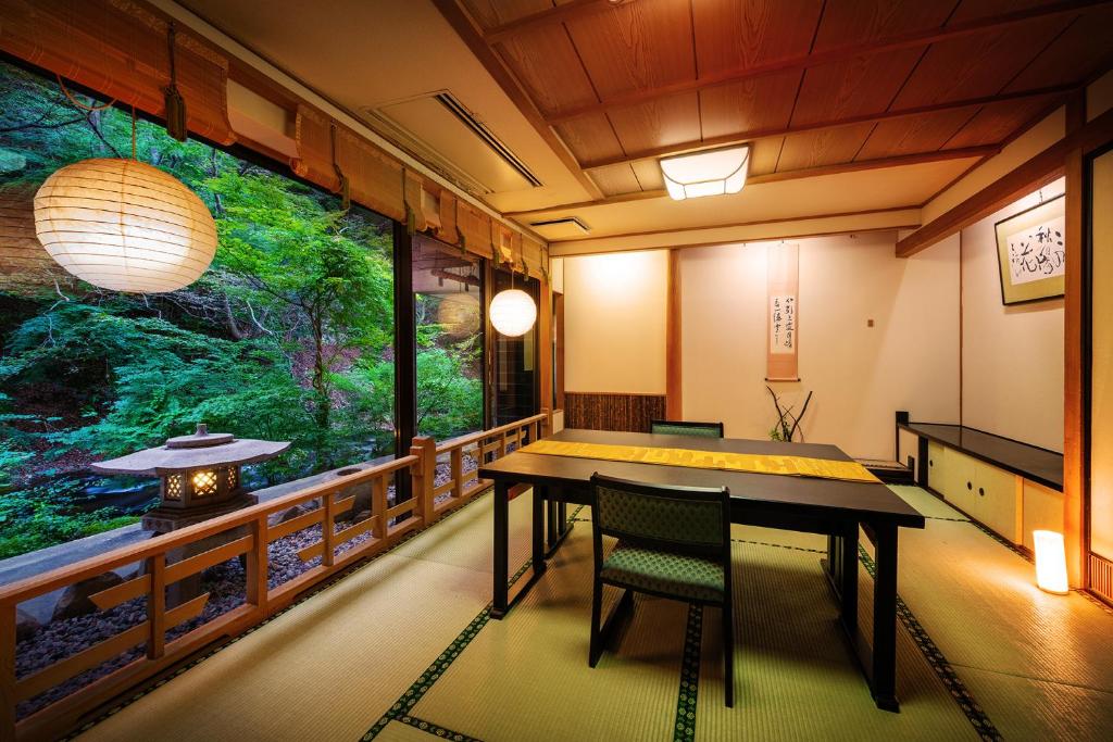 une pièce avec une table et des chaises et une grande fenêtre dans l'établissement Konjakutei, à Aizuwakamatsu