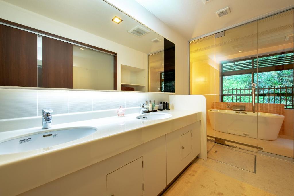 une salle de bain avec un lavabo et un grand miroir dans l'établissement Konjakutei, à Aizuwakamatsu