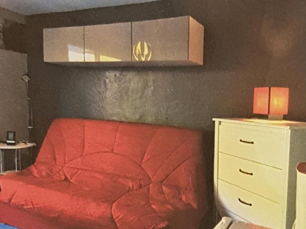 - une chambre avec un lit rouge et une commode blanche dans l'établissement CENTRE STATION Les 2 Alpes - 5 couchages - 450e par semaine seulement !, à Les Deux Alpes
