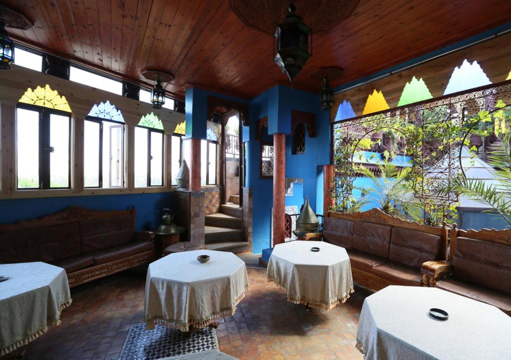 - un restaurant avec deux tables dans une salle avec fenêtres dans l'établissement Riad Hiba, à Meknès