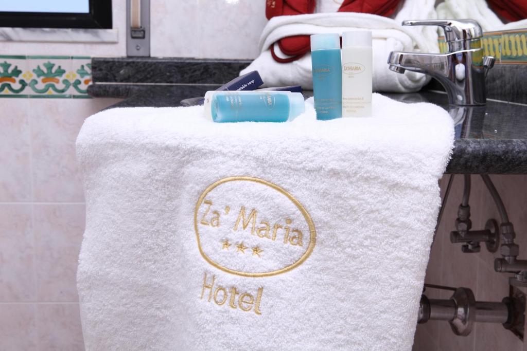 - une serviette blanche avec un panneau d'hôtel dans l'établissement Hotel Za Maria, à Santo Stefano di Camastra