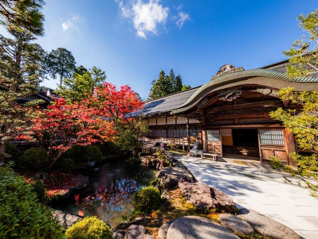 un bâtiment avec un étang devant dans l'établissement 高野山 宿坊 恵光院 -Koyasan Syukubo Ekoin Temple-, à Koyasan