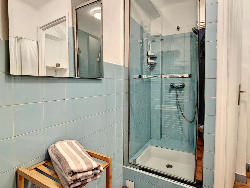 La salle de bains est pourvue d'une douche et d'une serviette sur une chaise. dans l'établissement Central Park Grand 2 Pieces centre Valberg, à Valberg