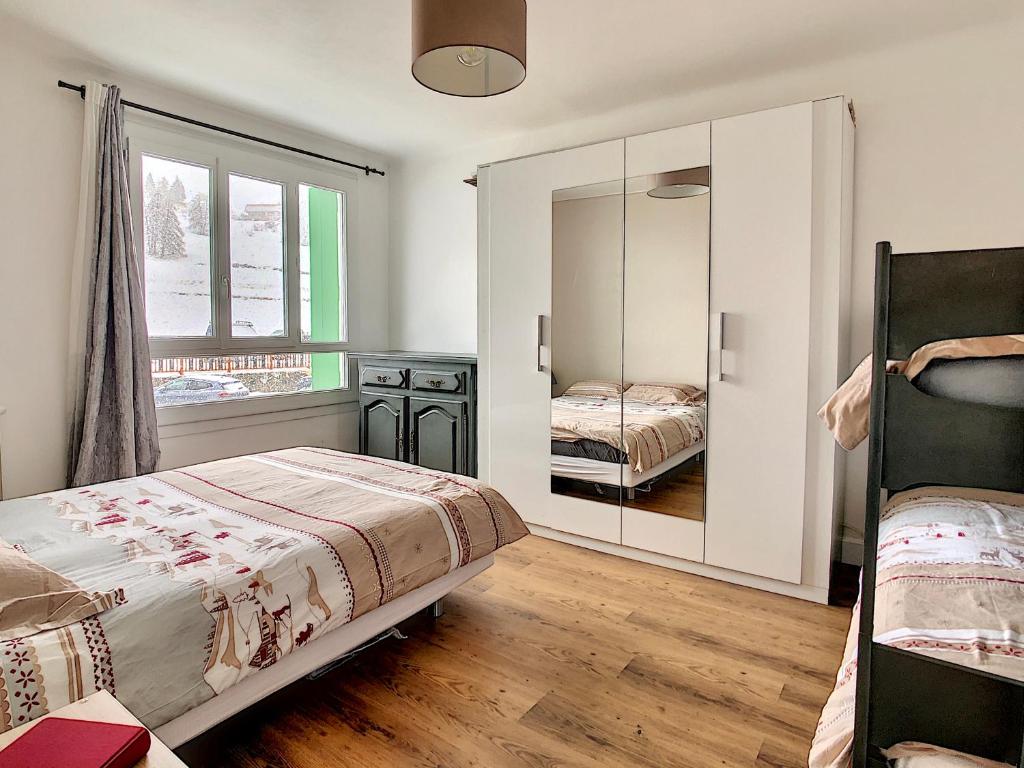 une chambre avec deux lits et un miroir dans l'établissement Central Park Grand 2 Pieces centre Valberg, à Valberg
