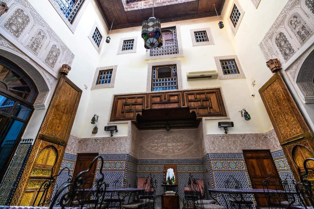 un bâtiment décoré avec des portes et des fenêtres en bois dans l'établissement Riad Fes Aicha, à Fès