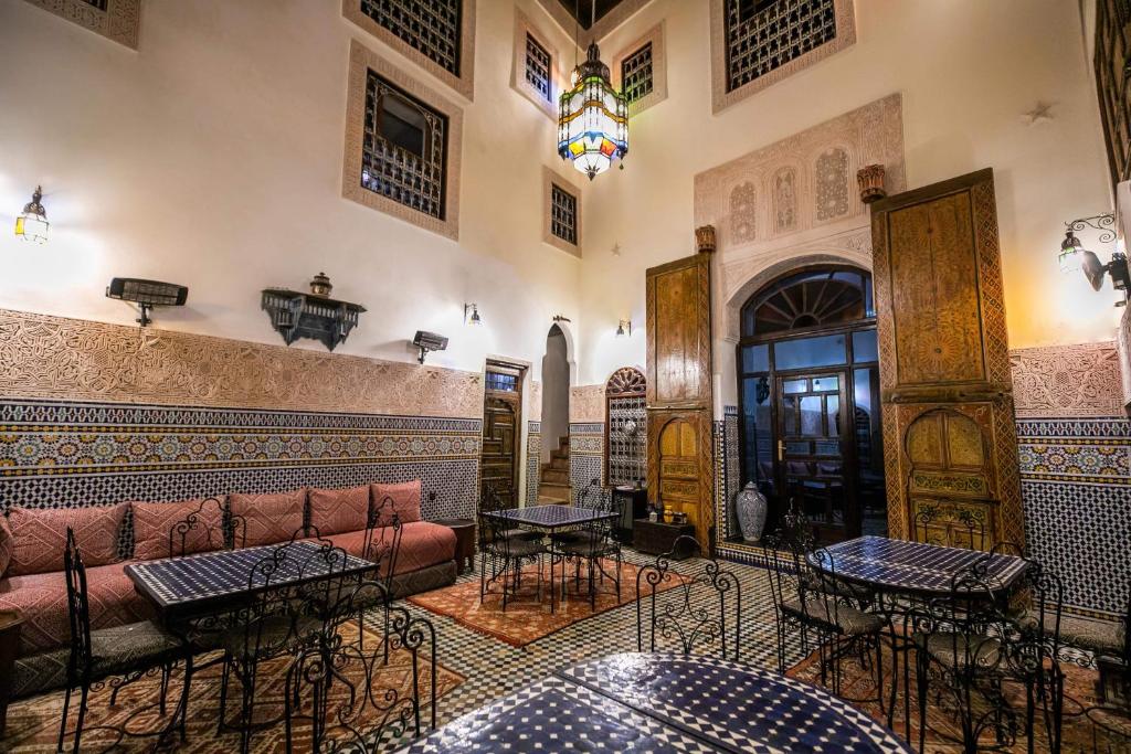 un salon avec un canapé et quelques tables dans l'établissement Riad Fes Aicha, à Fès