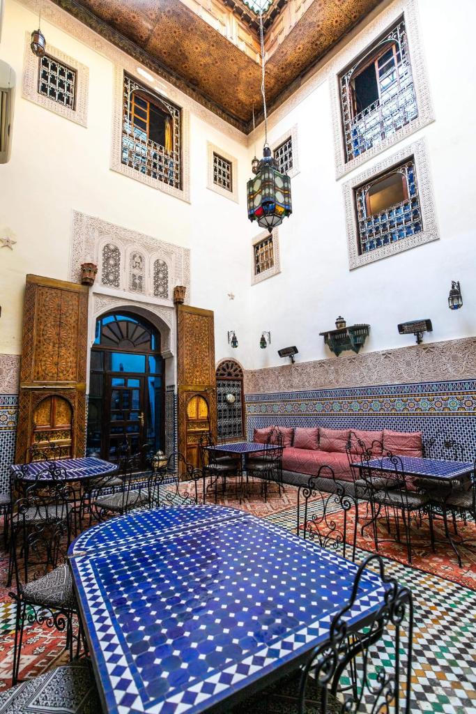 une pièce avec des tables et des chaises dans un bâtiment dans l'établissement Riad Fes Aicha, à Fès