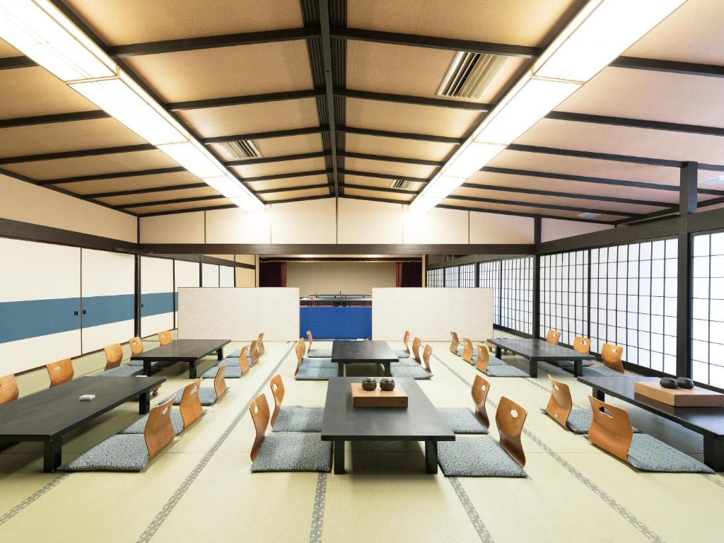 une salle de conférence avec des tables, des chaises et des fenêtres dans l'établissement HOTEL SHIRAHAMAKAN, à Shirahama