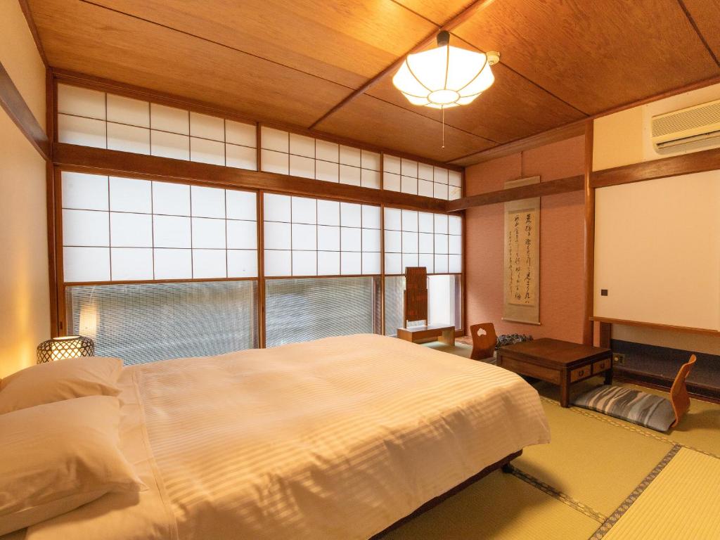 une chambre avec un grand lit et une grande fenêtre dans l'établissement HOTEL SHIRAHAMAKAN, à Shirahama