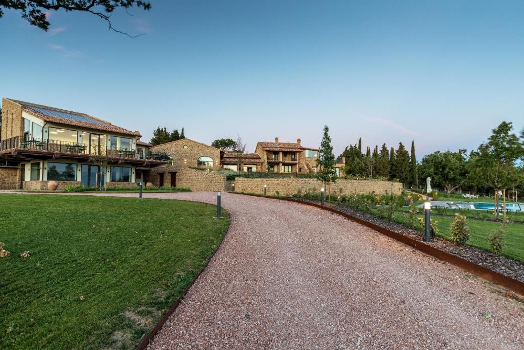 une maison avec une route en gravier en face d'une cour dans l'établissement Perugia Vecchia Relais, à Deruta