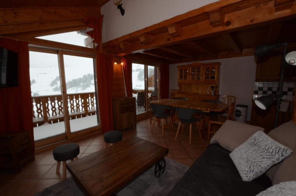 un salon avec un canapé et une table dans l'établissement Chalet A, Village des Lapons Les Saisies, 3 chambres et 1 espace nuit mezzanine, aux Saisies