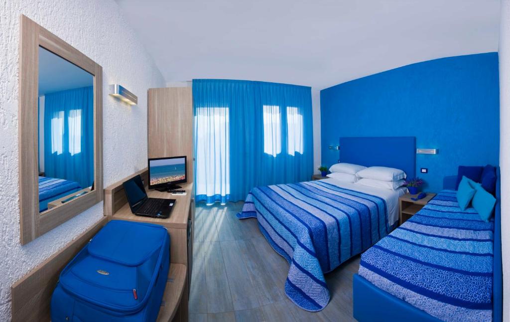 Cette chambre bleue comprend 2 lits et un bureau avec un ordinateur. dans l'établissement Hotel Napoleon, à Pesaro 26 autres photos