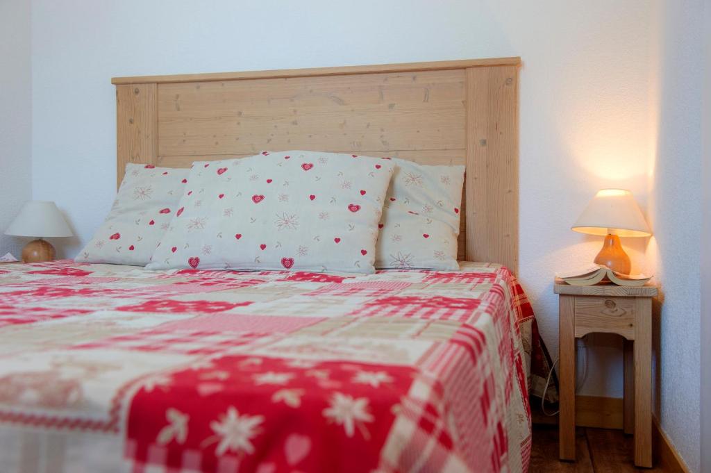 - un lit avec une couverture rouge et blanche et 2 lampes dans l'établissement Résidence Goélia Le Balcon des Neiges, à Saint-Sorlin-dʼArves 27 autres photos