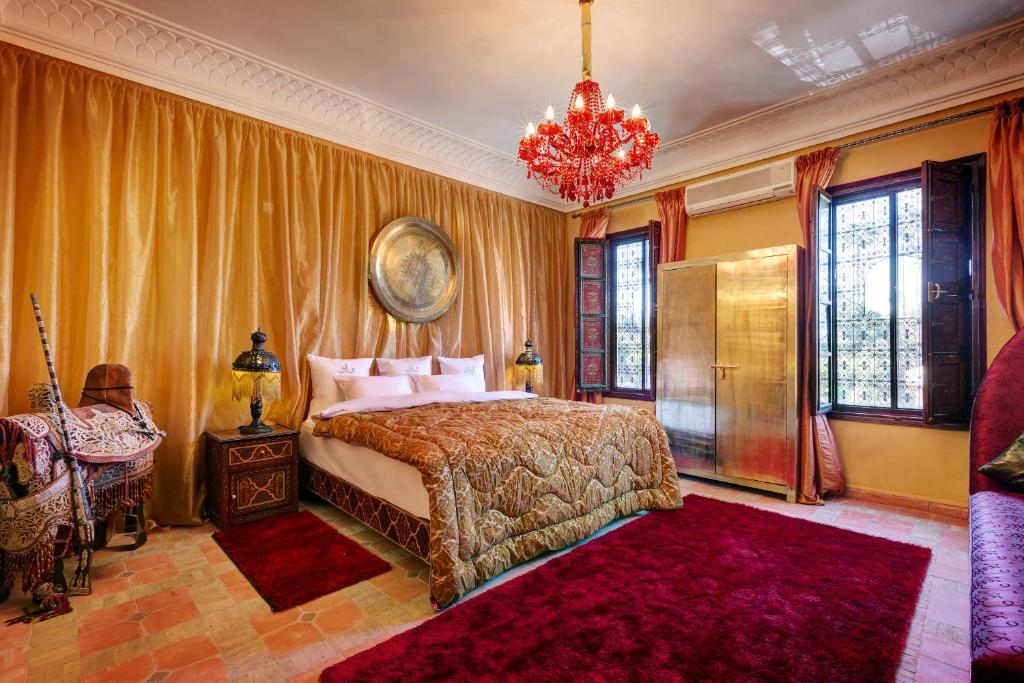 une chambre avec un lit et un lustre dans l'établissement Riad Wow, à Marrakech