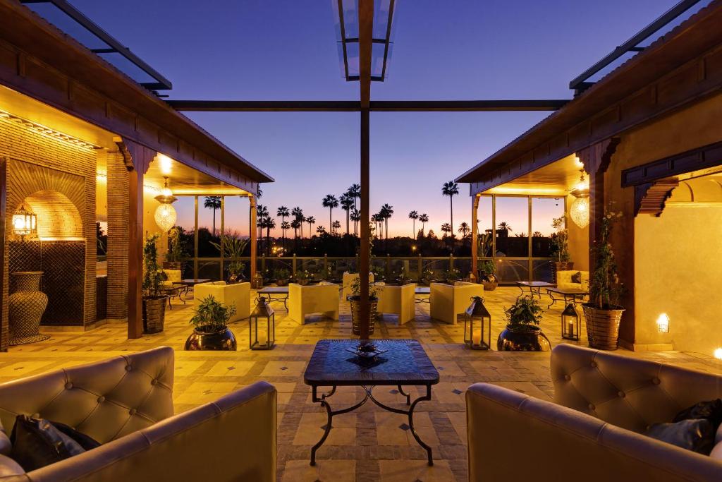 - une terrasse avec des canapés et une table la nuit dans l'établissement Riad Wow, à Marrakech