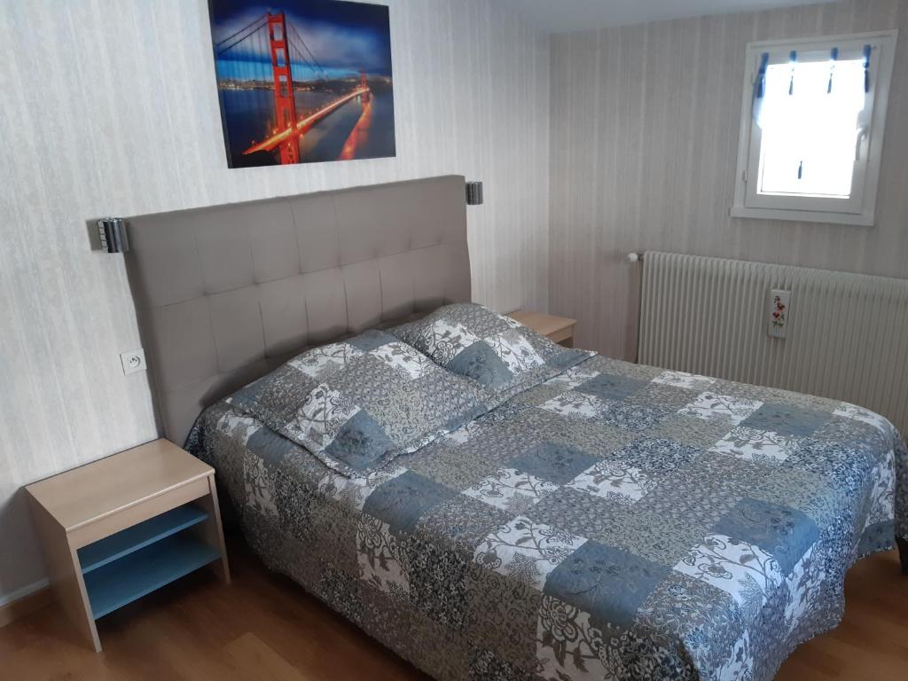 une chambre avec un lit avec une couette dessus dans l'établissement Gîte Les Glycines, à Gérardmer