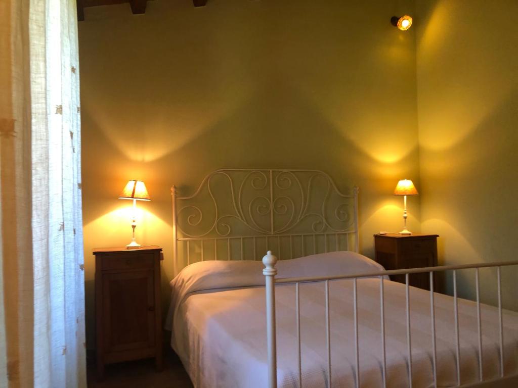 - une chambre avec un lit et deux lampes sur les tables dans l'établissement podere campanella, à Viterbe