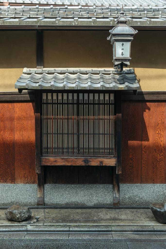 un banc éclairé sur le côté du bâtiment dans l'établissement Toshiharu Ryokan, à Kyoto