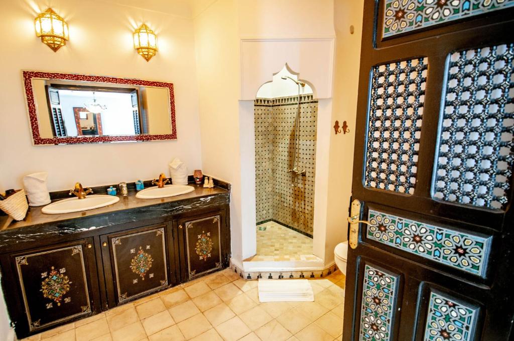 une salle de bain avec deux lavabos et une douche dans l'établissement Riad Makila, à Marrakech