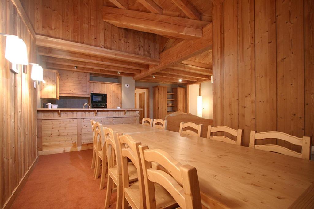 une grande salle à manger avec une longue table et des chaises dans l'établissement Vacancéole - Résidence l'Alba, à Les Deux Alpes